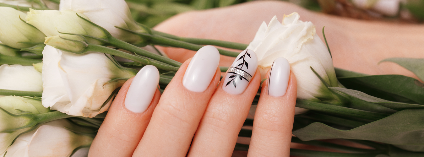White manicure resting among white flowers